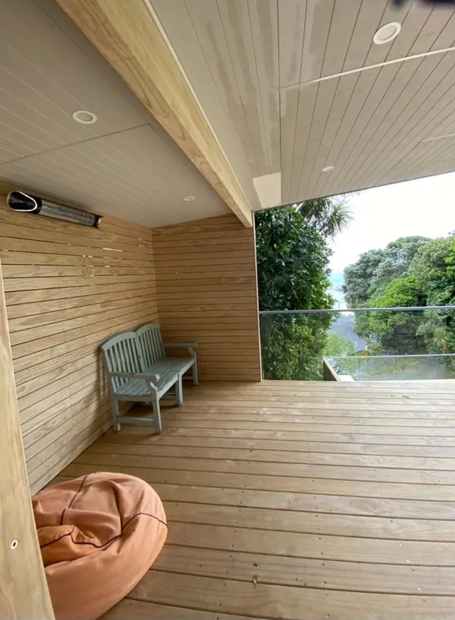 Covered outdoor room with timber-lined walls and ceiling over a deck