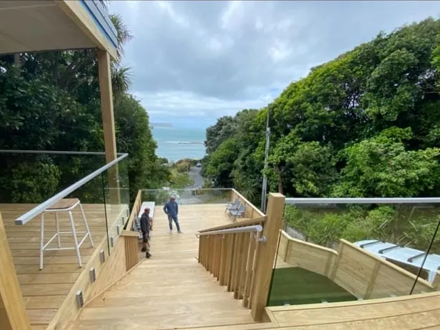 Wide timber stairs leading down to a lower deck with sea views