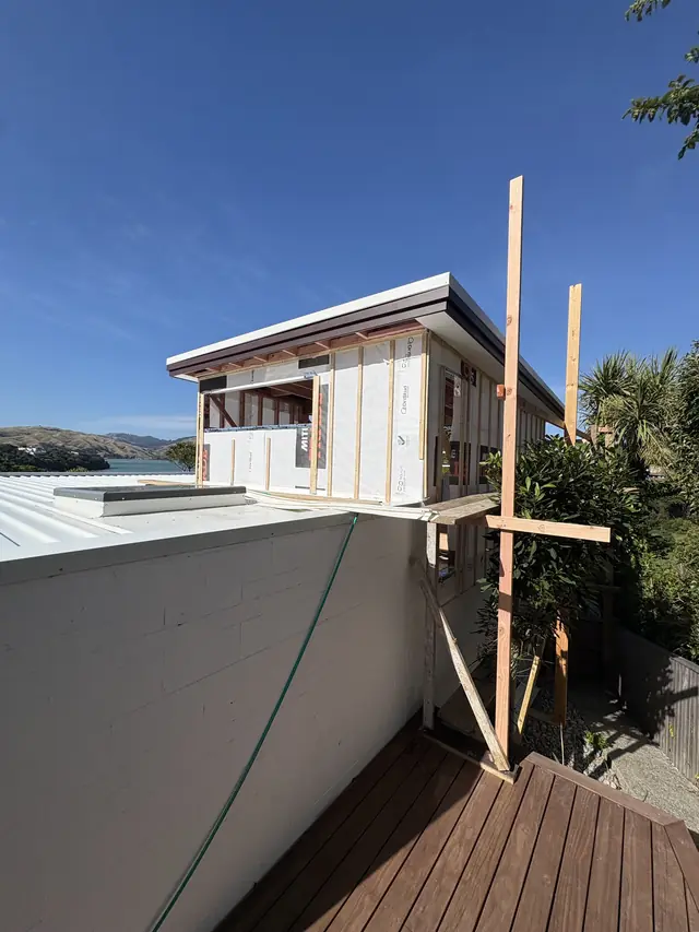 Extension framing braced on top of an existing home
