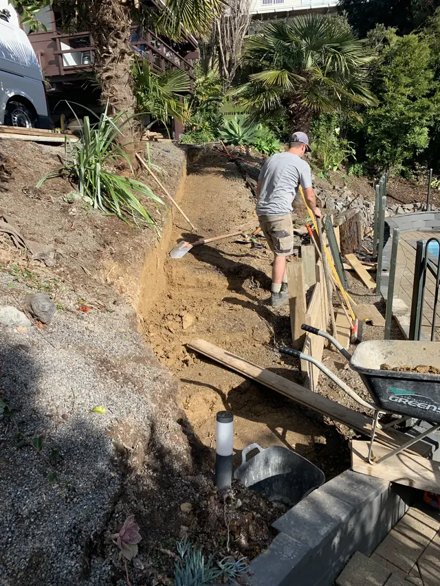 A worker digging out a sloping section by hand before retaining goes in