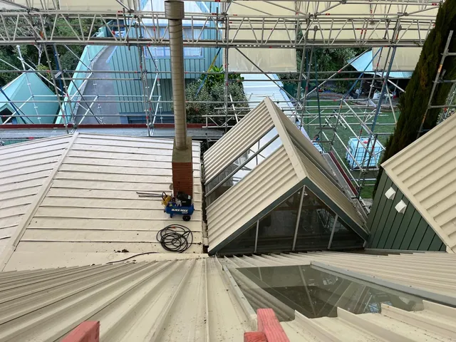 New roofing iron and a glazed gable seen from above, with scaffolding around the house